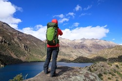 Woman backpacker hiking in beautiful winter mountains