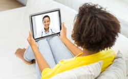 medicine, technology and healthcare concept - african young female patient having video chat with doctor on tablet pc computer at home