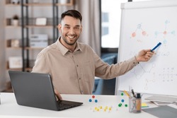 distance education, school and remote job concept - happy smiling male chemistry teacher with laptop computer having online class and showing molecular model on flip chart at home office