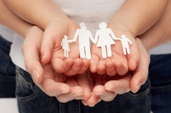 people, charity, family and care concept - close up of woman and girl hands holding paper family cutout