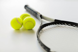 sport, fitness, healthy lifestyle and objects concept - close up of tennis racket with balls