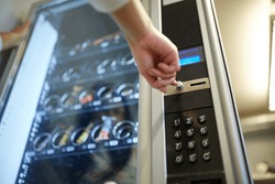 sell, technology and consumption concept - hand pushing button on vending machine operation panel