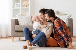 family, parenthood and people concept - happy mother, father with baby at home