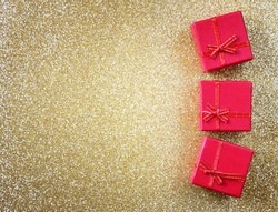 red gift boxes on glitter gold background 