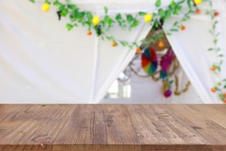 Jewish festival of Sukkot. Traditional succah (hut) with decorations. Empty wooden old table for product display and presentation.