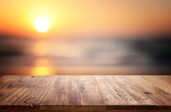 Wooden table and blurred sunset background. Summertime and vacation