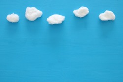 top view image of cotton shaped clouds over blue wooden background
