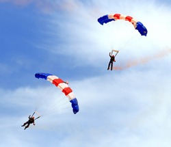 Paratroopers descending in a military skydiving parachute demonstration