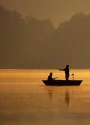 A pair of anglers are fishing on a beautiful golden morning.