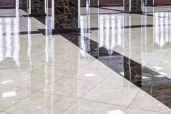Marble floor in luxury lobby of office or hotel. Clean floor tile with reflections for background. Shiny stone floor in commercial building after professional cleaning service.