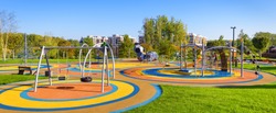 Panorama of colorful large playground in a city park. Empty modern outdoor playground in summer. Beautiful urban place for kids games and sport. Scenic view of children ground.