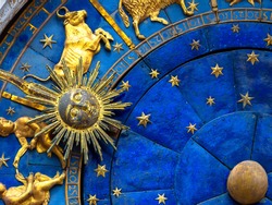 Taurus astrological sign on ancient clock. Detail of Zodiac wheel with Sun and Taurus. Golden symbol of bull on star circle closeup. Concept of astrology and horoscope.
