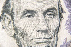 Abraham Abe Lincoln face on 5 dollar bill close up. Portrait of famous US president on dollar banknote. Macro view of USA paper money. Detail of new currency note.