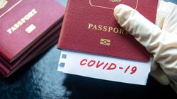 Travel and corona virus concept, a note COVID-19 in tourist passport. Medical test at border control due to COVID. Business and tourism hit by coronavirus, restrictions during pandemic.
