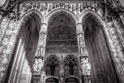 Ulm Minster or Cathedral of Ulm city, Germany. It is top landmark of Ulm. Front view of ornate entrance of old Gothic cathedral, luxury facade of famous medieval Christian church in black and white. 