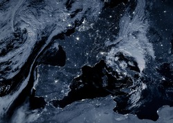 Europe at night, view of city lights showing human activity on continent from space. Earth surface and clouds on world dark map on global satellite photo. Elements of this image furnished by NASA.
