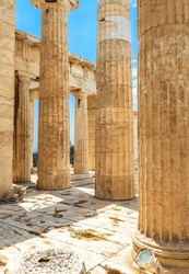 Ancient Greek ruins on Acropolis, Athens, Greece. Classical marble columns, remains of Propylaea Palace in Athens city center. Concept of past civilization, old temple, history and travel in Athens.