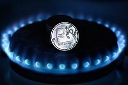Gas burner and ruble coin, Russian money on home gas stove. Blue propane gas flame and ruble currency. Concept of Russia and Europe economy, natural gas cost, inflation, sanctions and payment. 