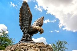 Eagle sculpture in Pyatigorsk, Stavropol Krai, Russia. Scenery of historical city landmark, old symbol of Pyatigorsk installed in 1901. Bronze statue on mountain top on sky background in summer.