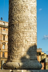 Detail of the column of Trajan in summer, Rome, Italy. This ancient column is most famous for its spiral bas relief and is one of the main landmark of Roma. Famous old column of Trajan in sunlight.