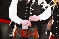 Color shot of a person holding a traditional bagpipe.