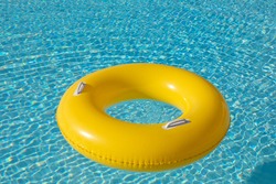 Yellow big float on pool with a blue water ready to swim