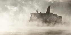 Large passenger ship (cruise liner) sailing near the coal terminal in a clouds of morning fog at sunrise. Riga bay, Baltic sea, Latvia. Epic seascape. Monochrome, atmospheric, concept image