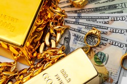 Jewelry buyer, pawn shop and buy and sell precious metals concept theme with a pile of cash in US dollars, golden rings, necklace bracelet and gold bullion isolated on white background