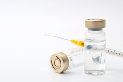 Vaccines, botulinum toxin and insulin ampules concept theme with glass vials with clear liquid next to a syringe and a hypodermic needle isolated on white background with copy space