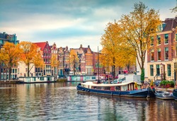Splendid autumn scene of Amsterdam city. Famous Dutch channels and great cityscape. Colorful morning landscape in Netherlands, Europe. Traveling concept background.
