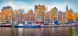 Panoramic autumn view of Amsterdam city. Famous Dutch channels and great cityscape. Splendid morning scene of Netherlands, Europe. Traveling concept background.