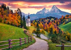 Iconic picture of Bavaria with Maria Gern church with Hochkalter peak on background. Fantastic autumn sunrise in Alps. Superb evening landscape of Germany countryside. Traveling concept background.