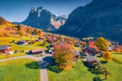 Aerial landscape photography. Colorful autumn view of Grindelwald village valley from cableway. Wetterhorn and Wellhorn mountains, Switzerland, Europe. Traveling concept background.