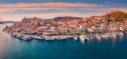 Fantastic sunset in Poros town. Picturesque summer seascape of Myrtoan Sea with a lots of yachts. Attractive evening scene of Peloponnese peninsula, Greece. Traveling concept background.