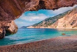 View from the cave of Myrtos bay. Colorful morning scene of Cephalonia island, Divarata village location, Greece, Europe. Astonishing summer seascape of Ionian Sea. Vacation concept background.