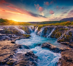 Extraordinary summer view of Bruarfoss Waterfall, secluded spot with cascading blue waters. Astonishing sunrise in Iceland, Europe. Beauty of nature concept background.