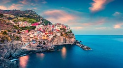 Second city of the Cique Terre sequence of hill cities - Manarola. Colorful spring sunset in Liguria, Italy, Europe. Picturesque seascape of Mediterranean sea. Traveling concept background.