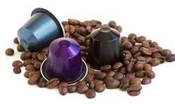 Italian espresso coffee capsules or coffee pods with some roasted coffee beans on white isolated background