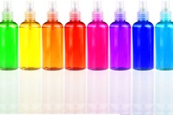 many colored bottles with cosmetics in a row