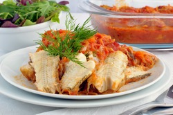 Marine fish baked with onions and carrots in tomato sauce