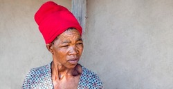 Poor African communities, old woman wrinkled face with red turban