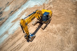 aerial view of an yellow excavator on the construction site