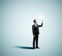 businessman holding lamp on a blue background