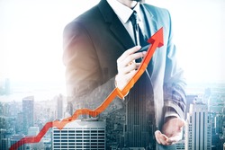 Businessman drawing upward red chart arrow on abstract city background. Growing sales concept. Double exposure