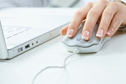 Closeup of female fingers and nails on computer mouse.