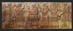 Ancient relief from Kalhu (Nimurid, Iraq) with Ashurnasirpal II king of Assyria on the throne with the Cup of sacrifice and is surrounded by a winged genius- patrons and courtiers