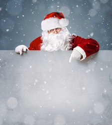 Santa Claus pointing in blank advertisement banner with copy space