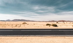 Empty road through the desert dunes with copy space