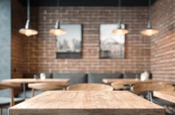 Empty coffee table over defocused coffee shop background with copy space
