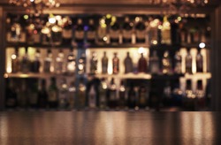 Empty wooden bar counter with defocused background of restaurant, bar or cafeteria and copy space